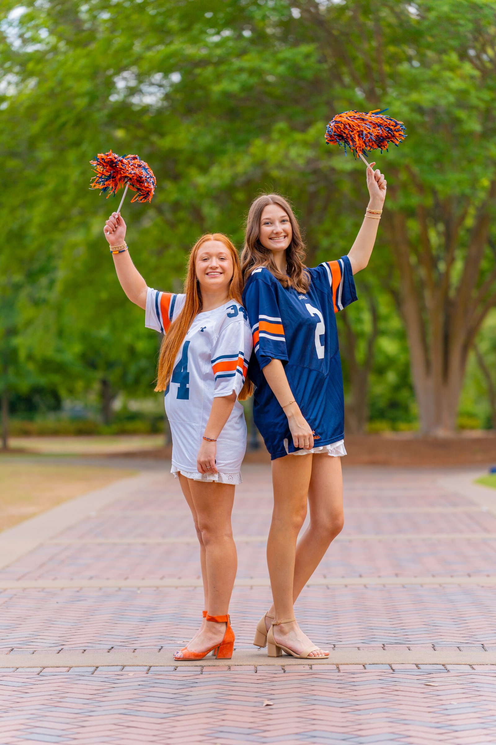 Two seniors in jerseys raising pom-poms